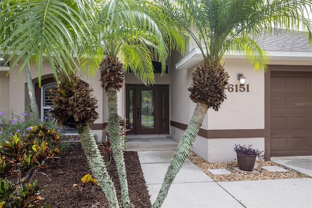 6151 Sabal Point Cir, Port Orange, FL 32128 - doorway to property with stucco siding, an attached garage, and a shingled roof