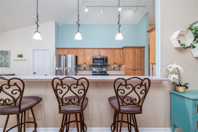6151 Sabal Point Cir, Port Orange, FL 32128 - kitchen featuring appliances with stainless steel finishes, decorative backsplash, a kitchen breakfast bar, hanging light fixtures, and brown cabinets
