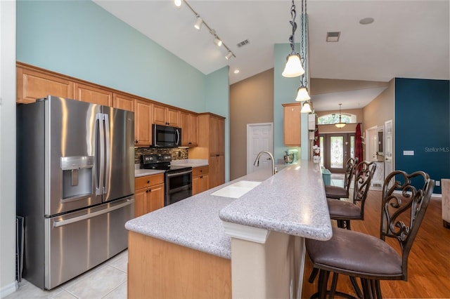 6151 Sabal Point Cir, Port Orange, FL 32128 - kitchen with stainless steel appliances, a kitchen breakfast bar, high vaulted ceiling, a peninsula, and hanging light fixtures