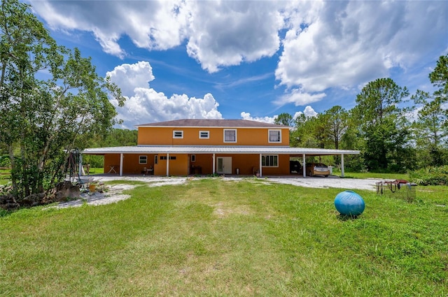 4666 Fir Rd, New Smyrna Beach, FL 32168 - back of house with an attached carport, driveway, a yard, and a metal roof