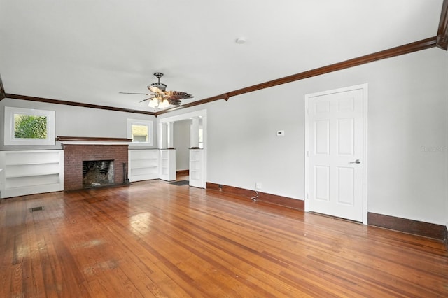 200 N St, Daytona Beach, FL 32114 - unfurnished living room featuring crown molding, wood-type flooring, ceiling fan, and a brick fireplace