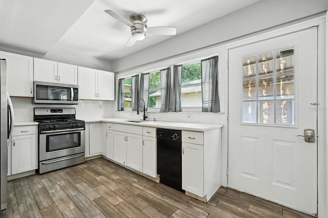 200 N St, Daytona Beach, FL 32114 - kitchen with appliances with stainless steel finishes, white cabinets, backsplash, and light countertops
