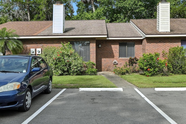 1512 Heritage Ln, Daytona Beach, FL 32117 - view of front of house with a chimney, brick siding, uncovered parking, and a shingled roof