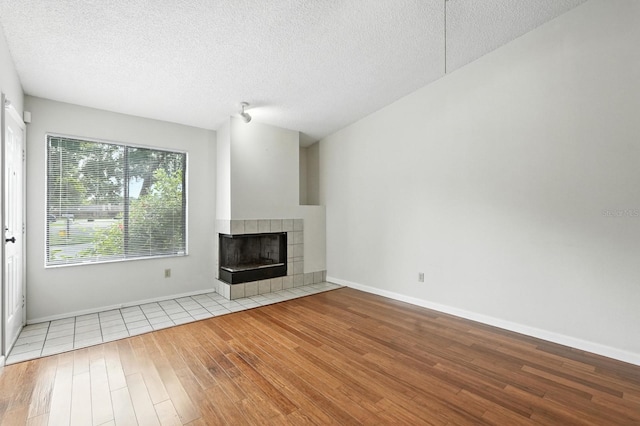 1512 Heritage Ln, Daytona Beach, FL 32117 - unfurnished living room featuring wood finished floors, a tile fireplace, and a textured ceiling