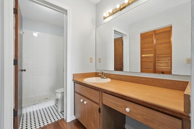 1512 Heritage Ln, Daytona Beach, FL 32117 - bathroom with vanity, tiled shower, wood finished floors, and a textured ceiling