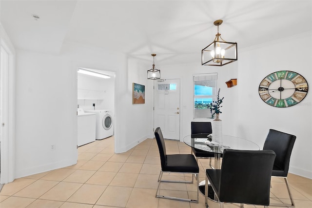 3315 S Atlantic Ave Unit 408, Daytona Beach Shores, FL 32118 - dining space with washing machine and clothes dryer, light tile patterned floors, a chandelier, and crown molding