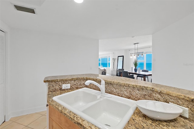 3315 S Atlantic Ave Unit 408, Daytona Beach Shores, FL 32118 - kitchen featuring light tile patterned floors, light countertops, and decorative light fixtures