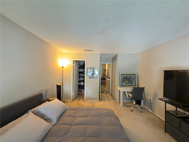4155 S Semoran Blvd Unit 8, Orlando, FL 32822 - bedroom featuring light carpet, a textured ceiling, and a walk in closet
