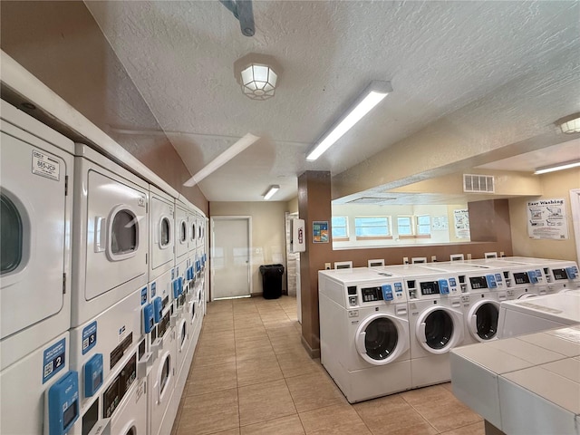 4155 S Semoran Blvd Unit 8, Orlando, FL 32822 - shared laundry room featuring stacked washing machine and dryer, separate washer and dryer, light tile patterned floors, and a textured ceiling