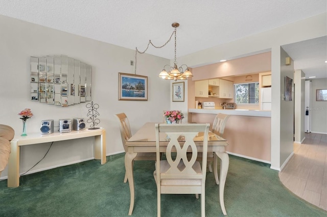 carpeted dining area featuring a textured ceiling and a chandelier