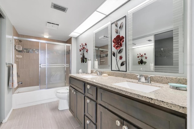 full bathroom with double vanity, toilet, combined bath / shower with glass door, and tile floors