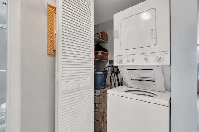 clothes washing area featuring stacked washer / dryer