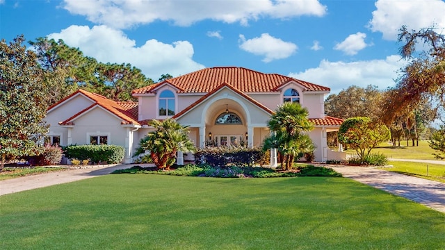 mediterranean / spanish home featuring a front lawn