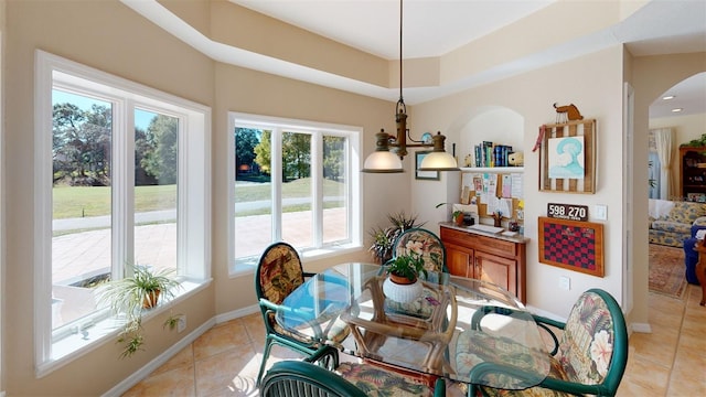 dining area featuring light tile patterned flooring and a raised ceiling