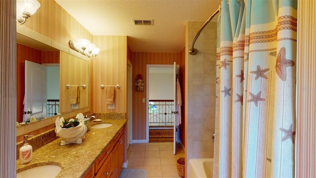 bathroom with tile patterned flooring, vanity, shower / tub combo, and a textured ceiling