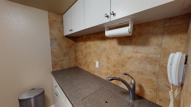 kitchen featuring white cabinetry, sink, and backsplash