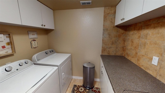 laundry room with cabinets, light tile patterned floors, and independent washer and dryer