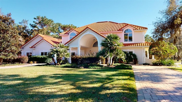 mediterranean / spanish home featuring a front lawn