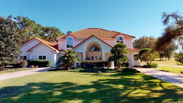 mediterranean / spanish home with a front lawn