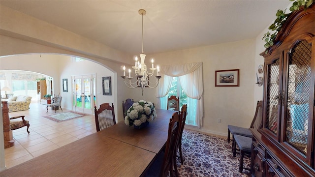 dining space with an inviting chandelier, tile patterned floors, plenty of natural light, and french doors