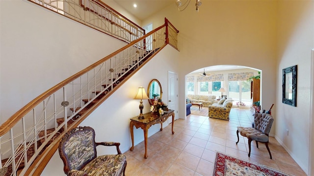 stairway featuring tile patterned flooring and a towering ceiling