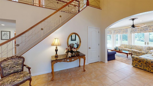 entrance foyer with a high ceiling, light tile patterned floors, and ceiling fan