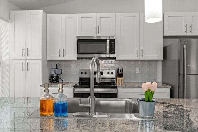 kitchen featuring tasteful backsplash, white cabinets, and appliances with stainless steel finishes