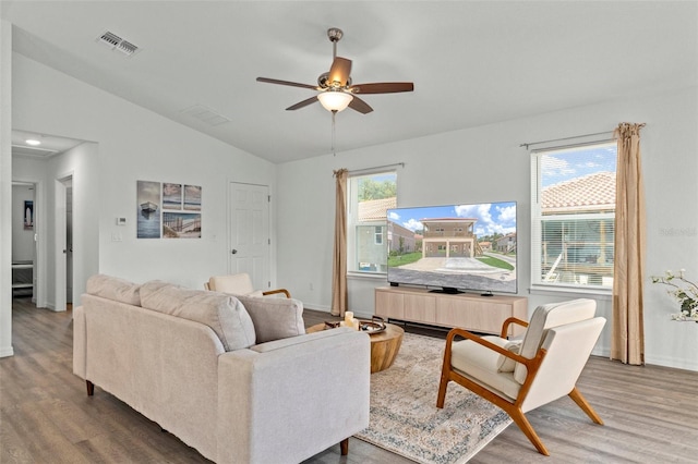 living room featuring ceiling fan, vaulted ceiling, and wood-type flooring