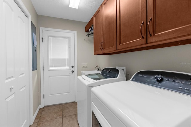 washroom featuring light tile patterned flooring, sink, cabinets, washing machine and dryer, and a textured ceiling