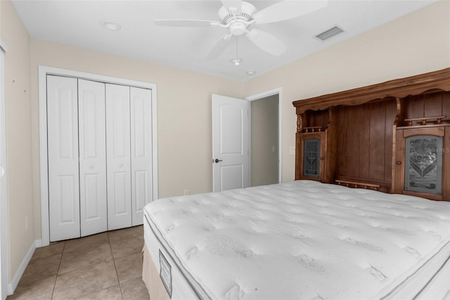 unfurnished bedroom with light tile patterned flooring, ceiling fan, and a closet