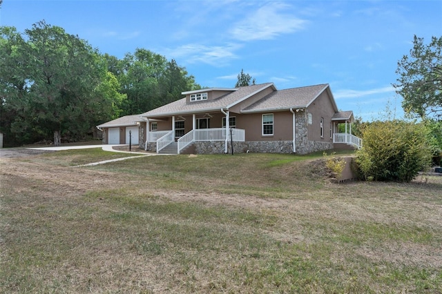 ranch-style house featuring a garage, a front yard, and covered porch