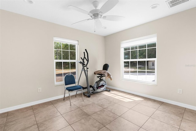 workout room featuring ceiling fan and light tile patterned flooring