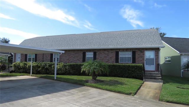 ranch-style home featuring a front lawn and a carport