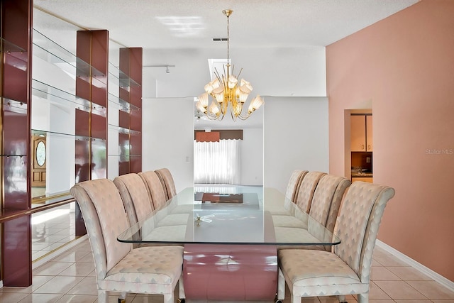 dining area featuring an inviting chandelier, a textured ceiling, and light tile floors