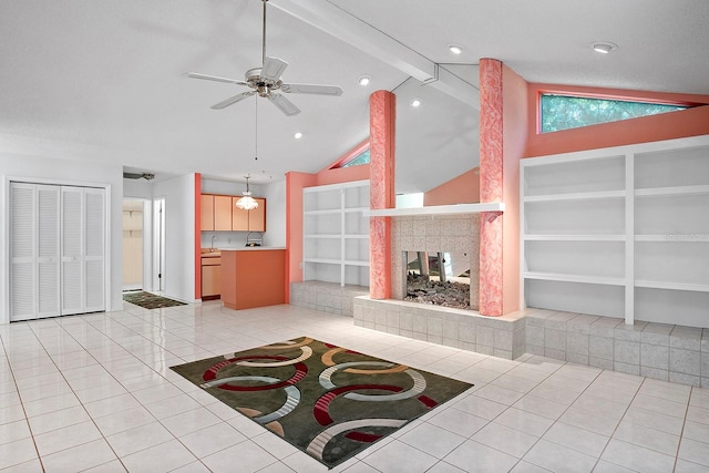 unfurnished living room with light tile floors, ceiling fan, vaulted ceiling with beams, and a tile fireplace