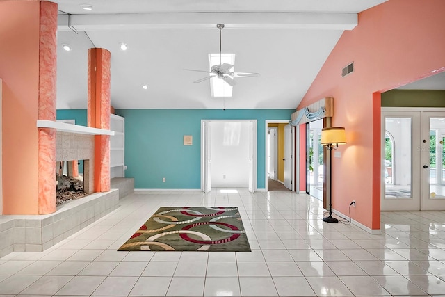 interior space featuring french doors, ceiling fan, a tile fireplace, high vaulted ceiling, and beam ceiling