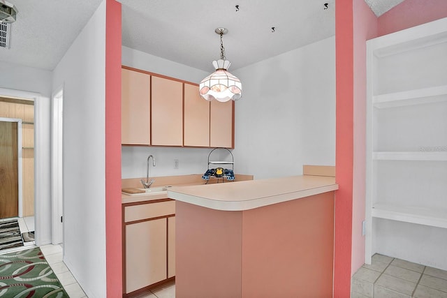 kitchen with sink, a textured ceiling, and light tile flooring