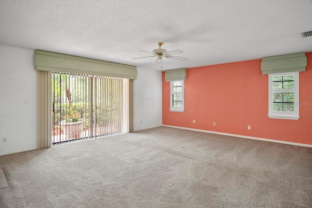 carpeted spare room featuring a textured ceiling and ceiling fan