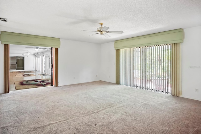 carpeted spare room with ceiling fan and a textured ceiling