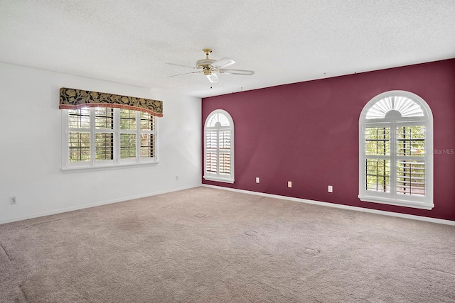 carpeted empty room with a textured ceiling and ceiling fan