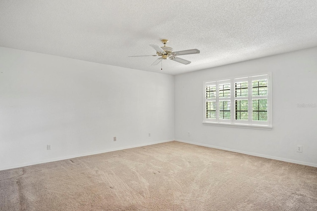 carpeted spare room featuring a textured ceiling and ceiling fan