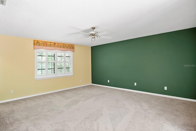 carpeted spare room with ceiling fan and a textured ceiling