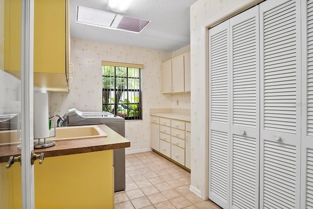 kitchen with light tile floors, a textured ceiling, and sink