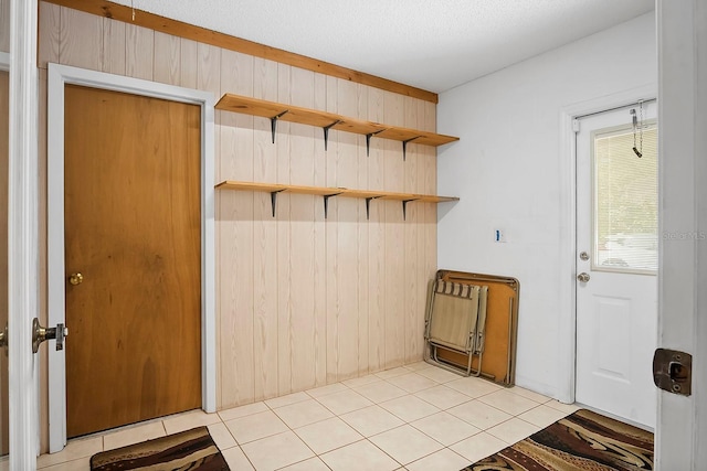 mudroom with light tile flooring and wood walls