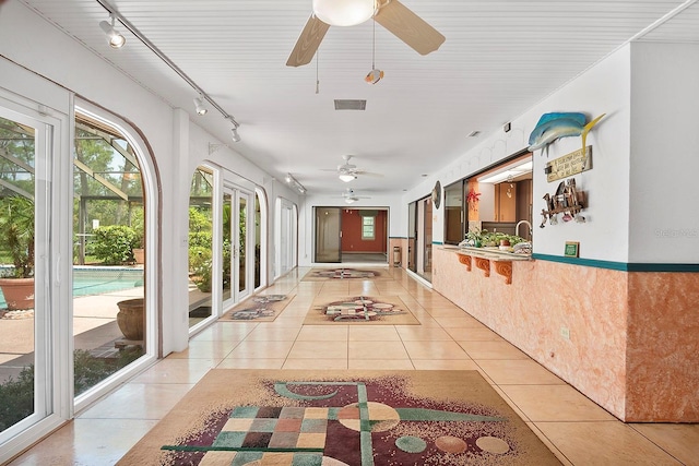 interior space featuring light tile floors, track lighting, and a wealth of natural light