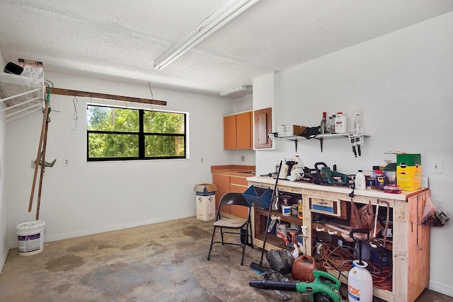 interior space with concrete flooring, a workshop area, and a textured ceiling