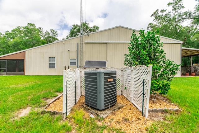 view of outdoor structure with a lawn and central air condition unit