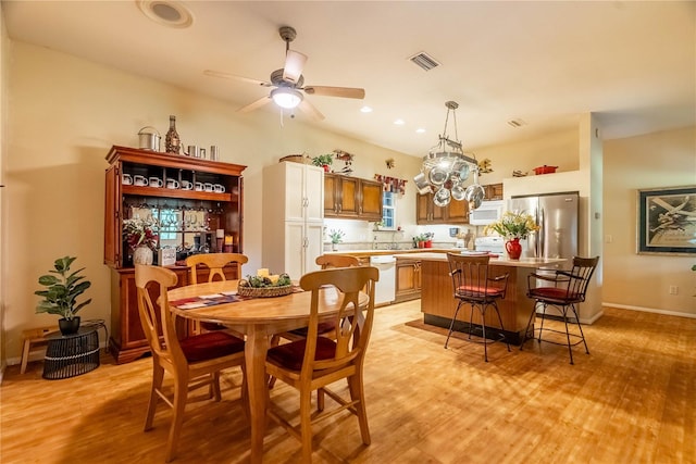 dining space with ceiling fan and light hardwood / wood-style flooring