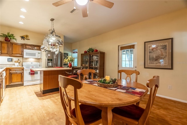 dining space with ceiling fan and light wood-type flooring