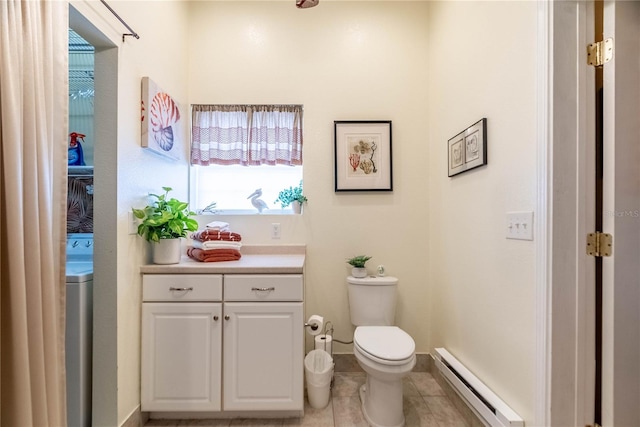 bathroom featuring baseboard heating, tile patterned flooring, washer / clothes dryer, toilet, and vanity